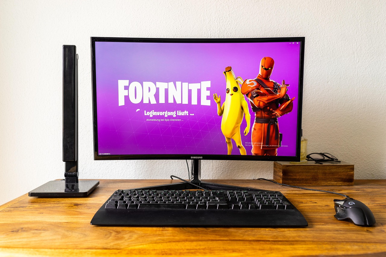 Smiling young man playing games on PC with headphones, enjoying a thrilling gaming session.